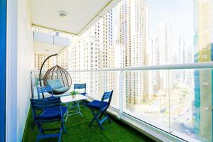 迪拜1BR Luxury Apartment close to JBR Beach Marina的阳台配有桌椅和大窗户。
