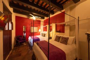 圣多明各埃尔比特里欧卡萨博物馆酒店的一间带两张红色墙壁床铺的卧室