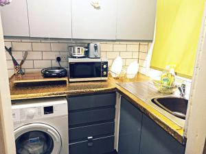 利兹Affordable Private Space的厨房配有洗衣机和水槽