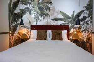 戛纳戛纳中心普鲁伊别墅酒店的卧室配有一张挂在墙上的植物大床
