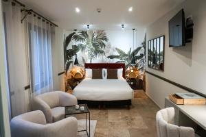 戛纳戛纳中心普鲁伊别墅酒店的一间卧室配有一张床和两把椅子