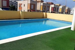 蒙科法尔Apartamento con piscina a pocos metros de la playa的建筑物屋顶上的游泳池