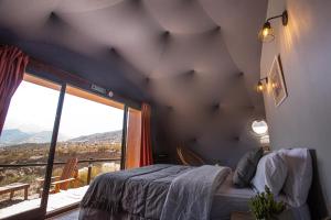 波特雷里约斯Denmoza Eco Lodge的一间卧室设有一张床和一个大窗户