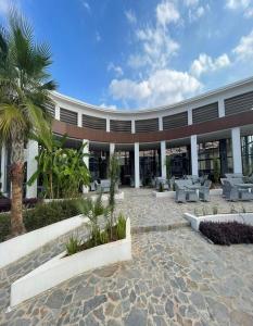 法马古斯塔Ekor Elegance Hotel的一座带庭院的建筑,庭院里设有桌子和棕榈树
