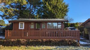 特兹西尼德Snowdonia Log cabin的一座小房子,设有大型木甲板