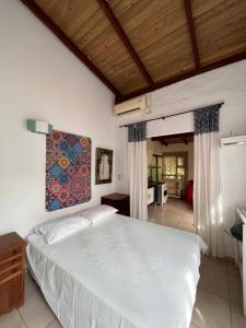 邦比尼亚斯Casa Mico Leão Dourado的卧室配有一张床,墙上挂有绘画作品