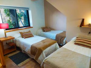 圣卡洛斯-德巴里洛切Tres Vistas的一间卧室设有两张床和窗户。