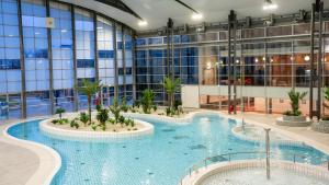 勒梅尼尔阿姆洛The Jangle Hotel - Paris - Charles de Gaulle - Airport的一座大型建筑,设有大型游泳池