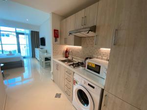 迪拜Black and white flower oasis in Seven Palm的厨房配有洗衣机和烘干机