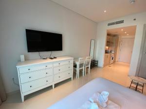 迪拜Black and white flower oasis in Seven Palm的客厅配有白色梳妆台和平面电视