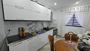 培拉特Guesthouse Albi的厨房配有白色橱柜、桌子和水槽。