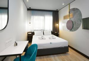 塞萨洛尼基Urban Elephant Suites的酒店客房,配有一张床、一张桌子和椅子