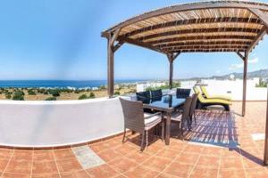 阿伊奥斯阿夫罗西奥斯Joya Cyprus Moonrise Penthouse Apartment的一个带桌椅的庭院和大海