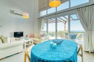 ArsosJoya Cyprus Sea Sunset View Garden Apartment的客厅配有一张带蓝桌布的桌子