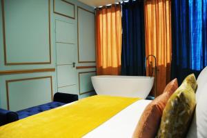 巴黎ROYAL SUITE PARIS REPUBLIQUE的一间卧室配有一张床和浴缸