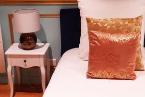 巴黎ROYAL SUITE PARIS REPUBLIQUE的一张带枕头的床和边桌上的灯