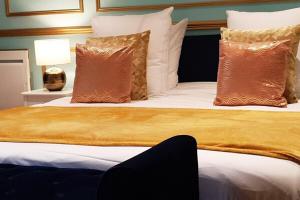 巴黎ROYAL SUITE PARIS REPUBLIQUE的一间卧室配有一张大床,提供棕色和白色的枕头