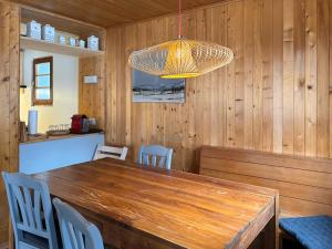 埃沃莱讷Chalet Marolly - Evolène的一间带木桌和吊灯的用餐室