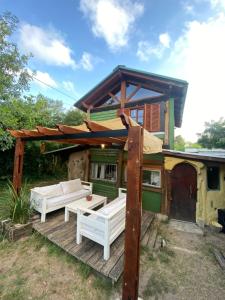 NeptuniaCabaña La Sencillita的一座带2个白色长椅的木甲板的房子
