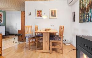 尼斯泰兹3 Bedroom Amazing Home In Nysted的厨房以及带木桌和椅子的用餐室。