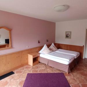 拉策堡姆勒法赫纳尔酒店的一间卧室配有一张大床和镜子