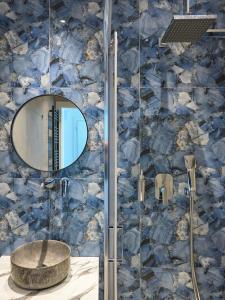 塞萨洛尼基Urban Elephant Suites的带淋浴、水槽和镜子的浴室