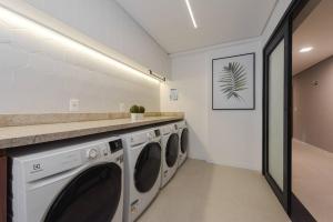佩洛塔斯Loft 804 com vista Parque Una的洗衣房配有3台洗衣机和1个柜台