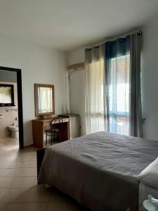维纳克斯特里奇L’ Aia di San Giorgio的一间卧室配有一张床、一张书桌和一个窗户。