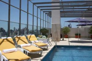 罗萨里奥阿里斯顿酒店 的一座带椅子和遮阳伞的游泳池
