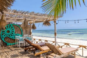 江比阿Pili Pili Sunrise的海滩上设有椅子和遮阳伞,大海