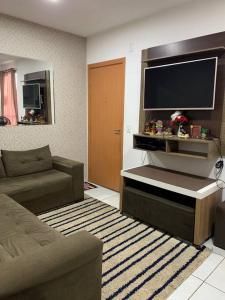 帕尔马斯Um apartamento bem aconchegante!的带沙发和大电视的客厅