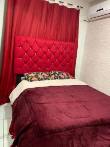 帕尔马斯Um apartamento bem aconchegante!的红色的床,红色床头板在房间内
