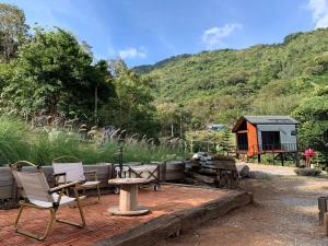 Klang DongThe Signature Valley Khao-yai Campus的一个带桌椅的庭院和小屋