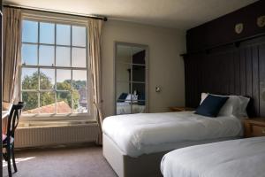 滕特登白狮宾馆的酒店客房设有两张床和窗户。
