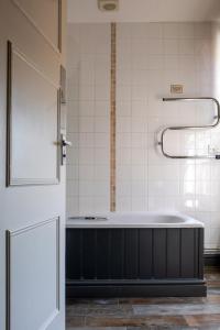 滕特登白狮宾馆的客房内的浴室设有大浴缸
