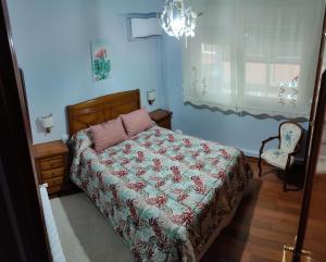 维戈Apartamento Turístico Menéndez Pelayo -Vigo的卧室配有床、椅子和窗户。