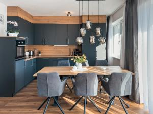 施利特尔斯AlpenLuxus' SIGIS Zillertalblick with 3 Bedrooms & Parking Space的厨房配有蓝色橱柜和木桌及椅子