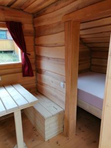 上施陶芬Wolpertinger | Camping-Aach的小木屋内的房间,配有一张床和一张长凳