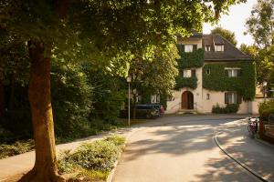 慕尼黑Gästehaus Englischer Garten的街上的房屋,有树和车道