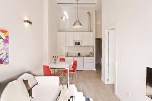 格拉纳达Casa Miravalle Darro的白色的客厅配有桌子和红色椅子