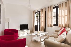 格拉纳达Casa Miravalle Darro的客厅配有红色椅子、沙发和电视