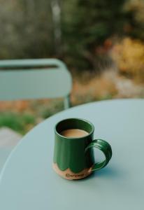 TofteTofte Trails的坐在桌子上的一个绿咖啡杯