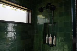TofteTofte Trails的绿色瓷砖淋浴间,配有2瓶洗发水