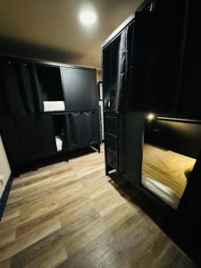 纽约KAMA CENTRAL PARK的客房设有黑色双层床和木地板。