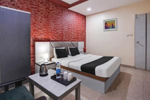 艾哈迈达巴德水晶酒店的一间卧室配有一张床和一张沙发桌子