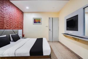 艾哈迈达巴德水晶酒店的一间卧室配有一张大床和一台平面电视