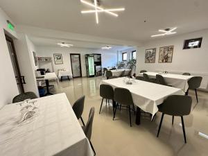 莱斯诺夫Emerald Residence的一间设有白色桌椅的用餐室