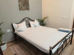 大诺伊达Risals Home Stays的一张带白色床单和枕头的床