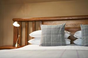 HalkirkUlbster Arms Hotel near Thurso的一间卧室配有带枕头和台灯的床