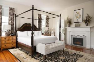 查尔斯顿The Jasmine House的一间卧室配有一张床、一把椅子和一个壁炉